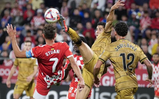 Aguerd despeja un balón ante el delantero del Girona Stuani, en presencia de Javi López. / DAVID BORRAT