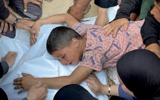 Un menor abraza el cadáver de un palestino asesinado en Gaza.