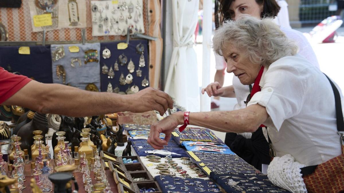 Una mujer mayor, viendo los artículos de joyería de una de los puestos de la Taconera.