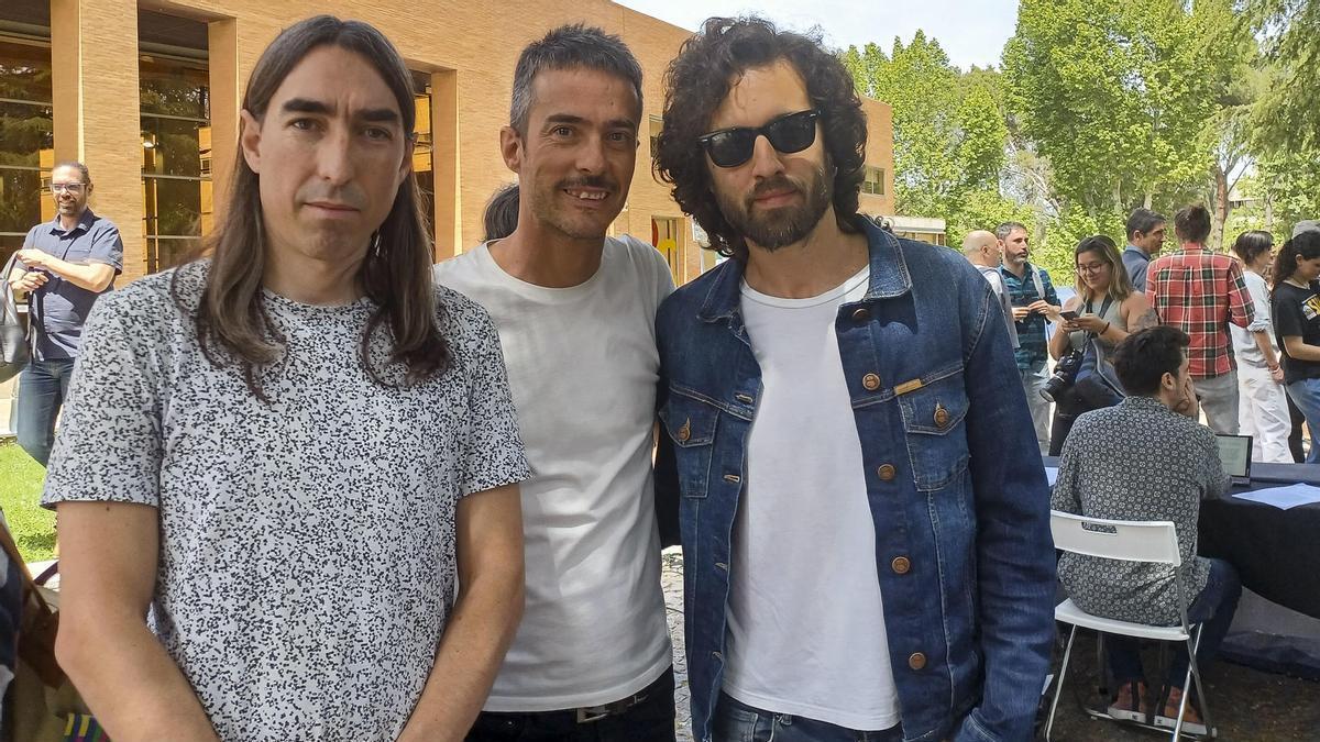 David García (i), Pucho (c), y Guillermo Galván (d), componentes del grupo Vetusta Morla, en la acampada en la explanada de la Universidad Complutense.