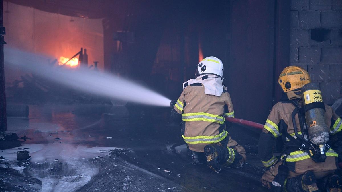 Bomberos durante un incendio en un almacén en la provincia de Jahra, en Kuwait