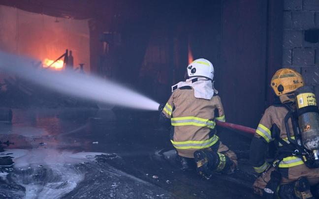 Bomberos durante un incendio en un almacén en la provincia de Jahra, en Kuwait