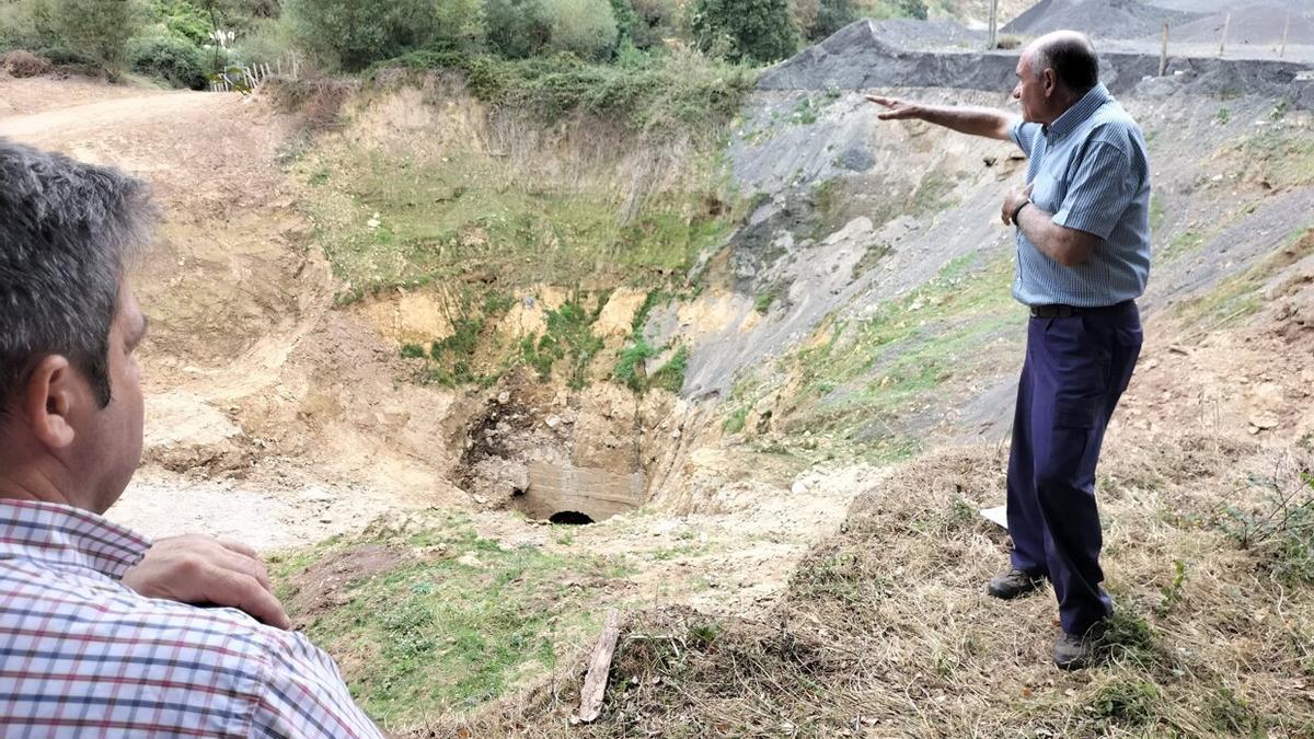 Unas personas señalan la zona donde se produjo el hundimiento de tierras.