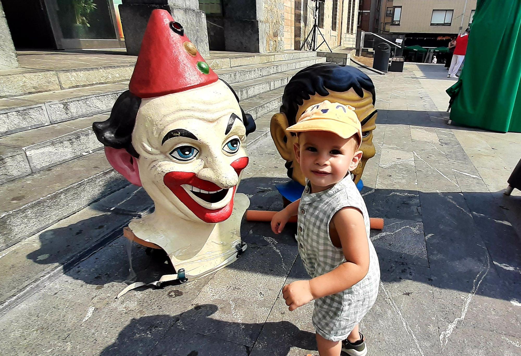 Un niño divirtiéndose con dos cabezudos este mediodía en la Plaza Juan Urrutia