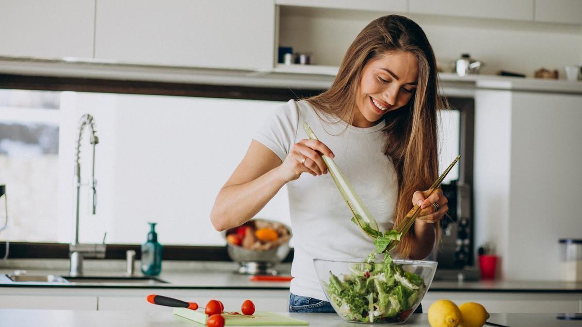 Chica prepara una ensalada.