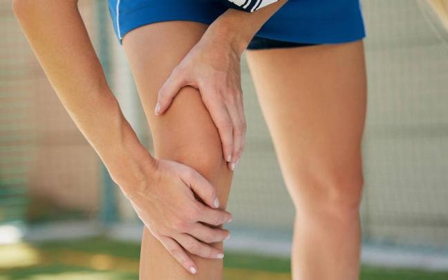 Una deportista con molestias se lleva las manos a la rodilla