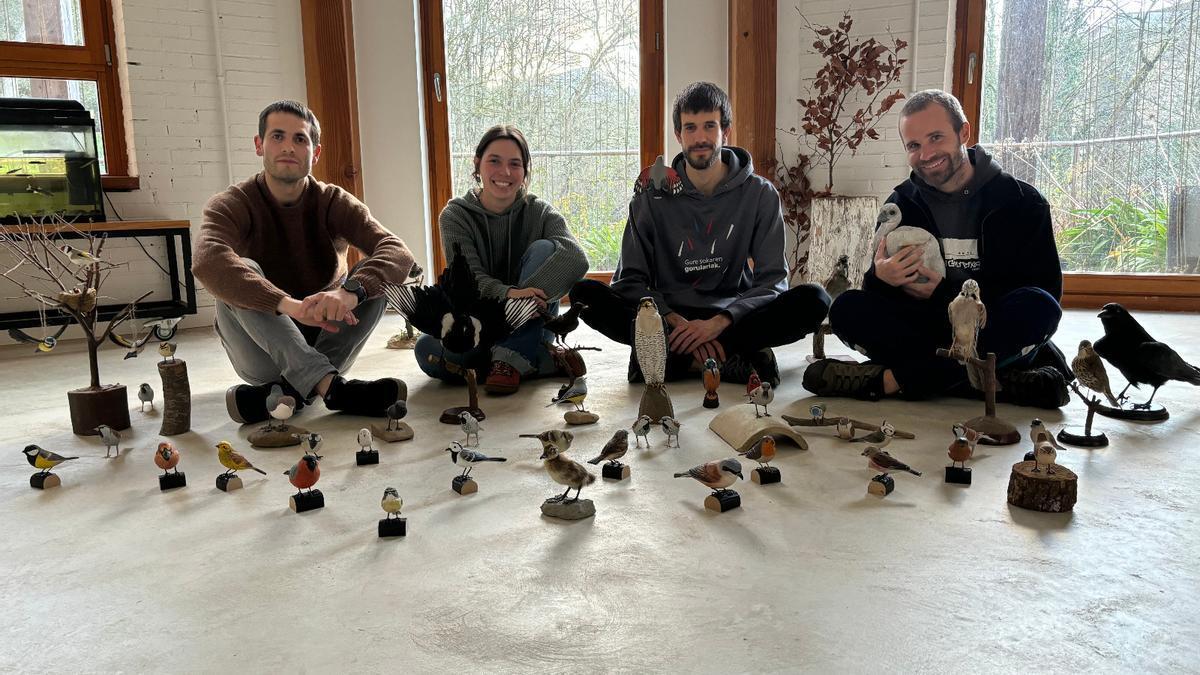 Educadores y educadora de la Natur Eskola con los pájaros tallados en madera que se mostrarán en la exposición.