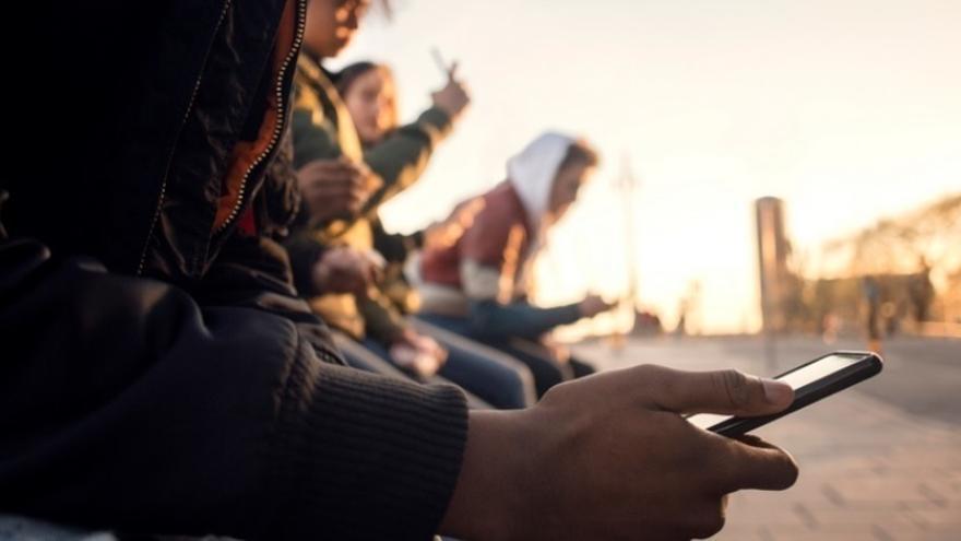 Un grupo de adolescentes con sus teléfonos móviles.