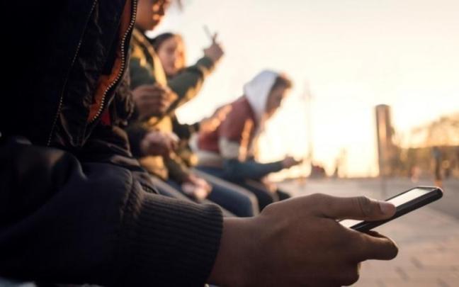 Un grupo de adolescentes con sus teléfonos móviles.