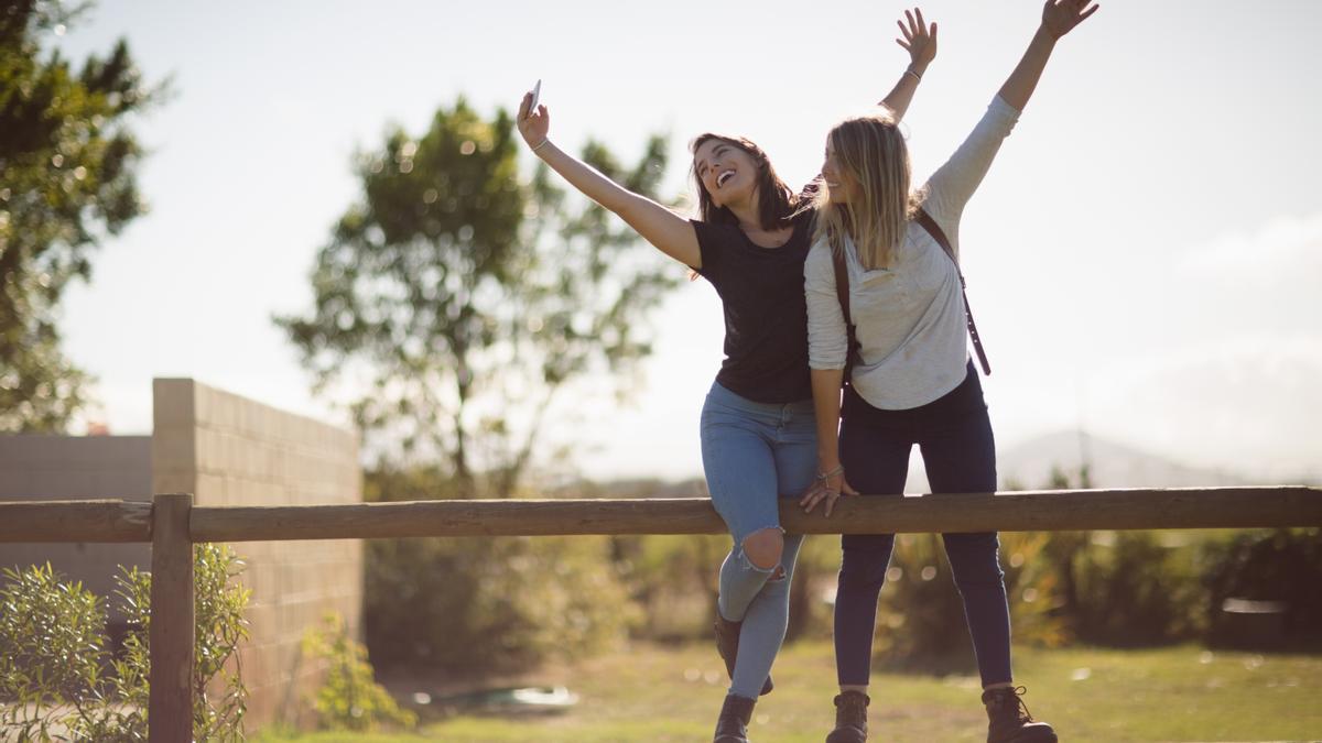 Dos amigas disfrutan sacándose un 'selfie' con el móvil.