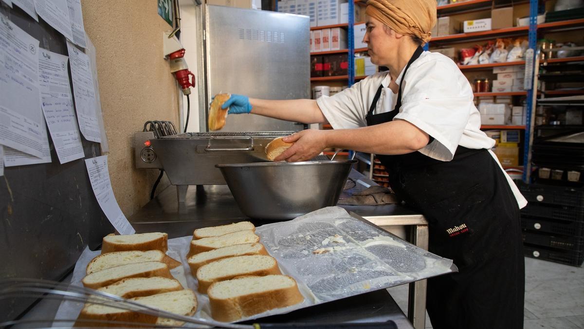 Una mujer trabaja en la elaboración de torrijas.