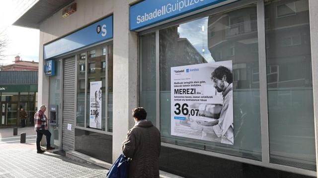 Unas personas pensionistas, en los aledaños de la sucursal de una entidad financiera en Bilbao