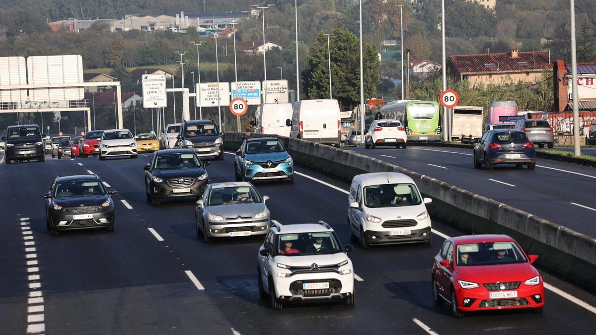 Tráfico denso en una carretera con señales de limitación de velocidad.