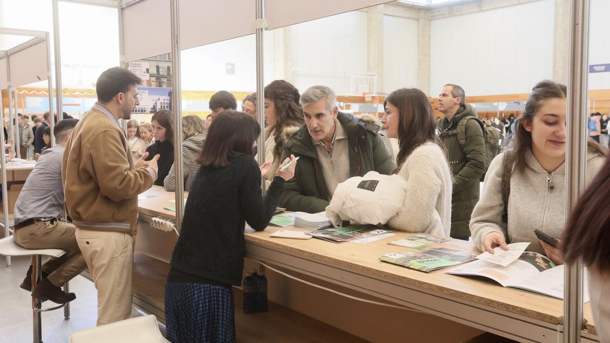 Jóvenes acuden junto a sus padres en una feria de orientación universitaria.