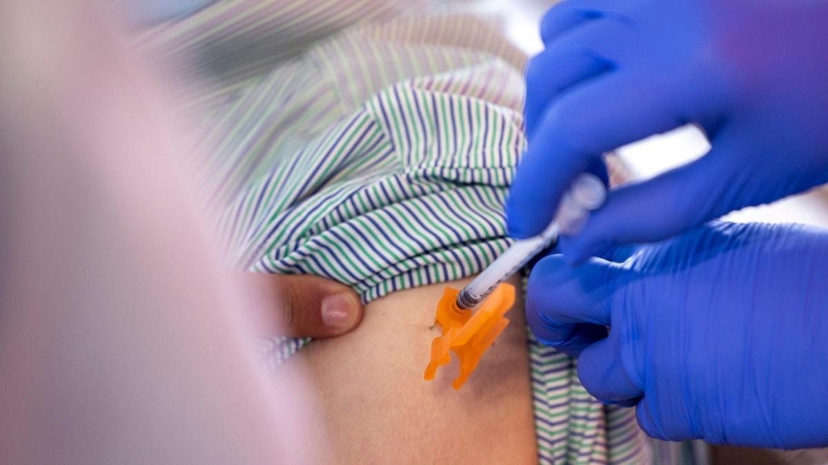 Un enfermero suministra una vacuna.