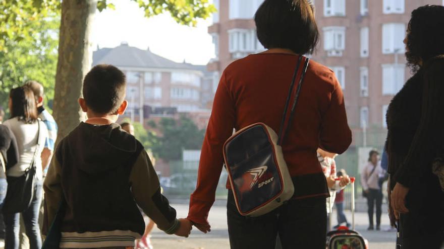 Un niño acude al colegio acompañado por su madre.