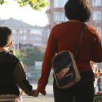 Un niño acude al colegio acompañado por su madre.