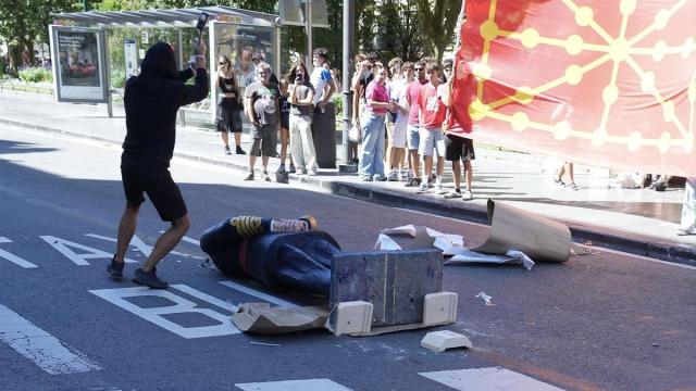 Varios manifestantes encapuchados derriban una estatua de Felipe VI durante la manifestación de la organización juvenil Ernai.