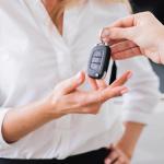 Una mujer recibe la llave de un coche.