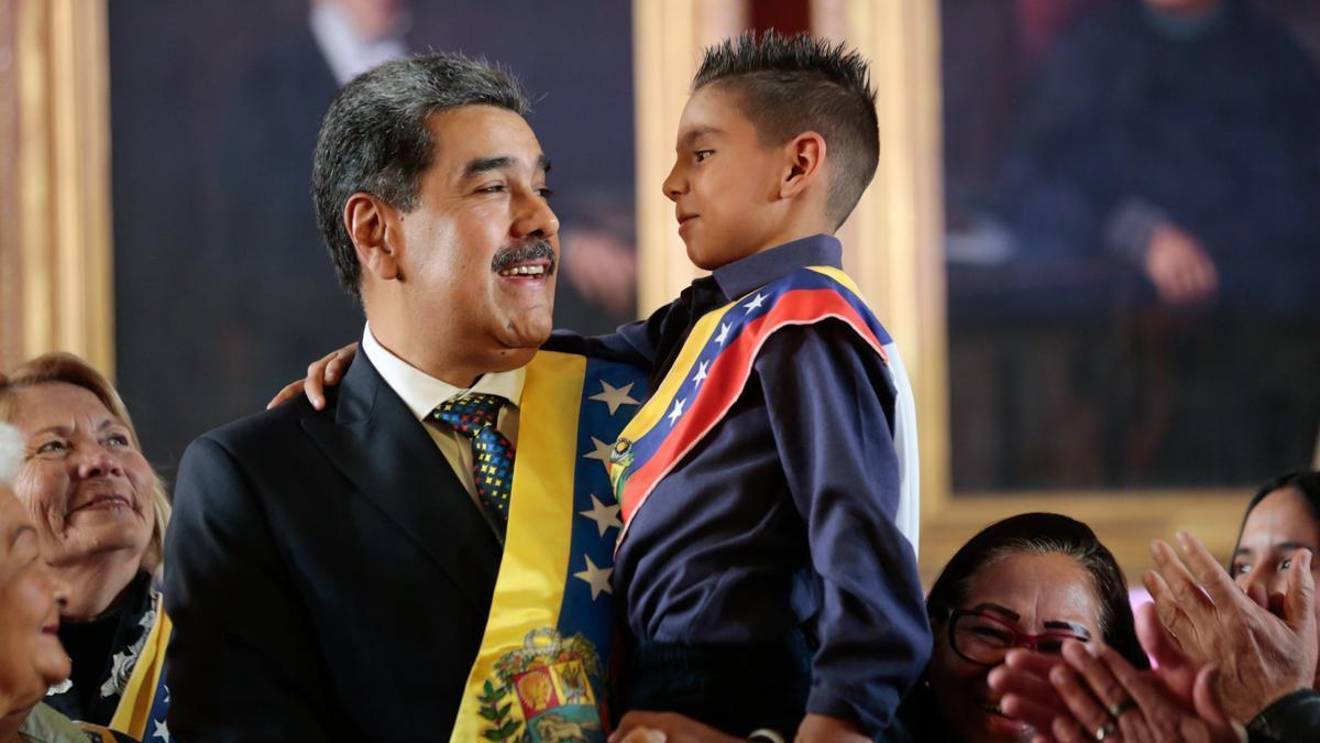 Maduro sostiene en brazos a un niño tras jurar como presidente de Venezuela.