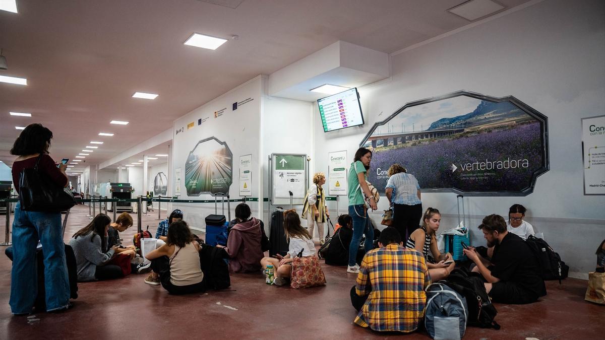 Varias personas esperan dentro de las instalaciones de la estación del tren de Chamartín con motivo de la incidencia entre Madrid-Levante.