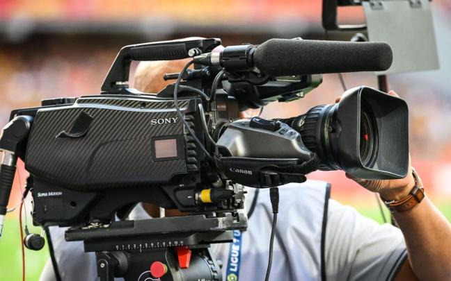 Un cámara de televisión durante un partido de fútbol.