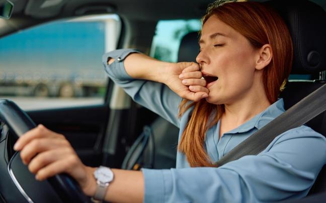 Una mujer bosteza mientras conduce su coche. / Freepik Una mujer bosteza mientras conduce su coche.