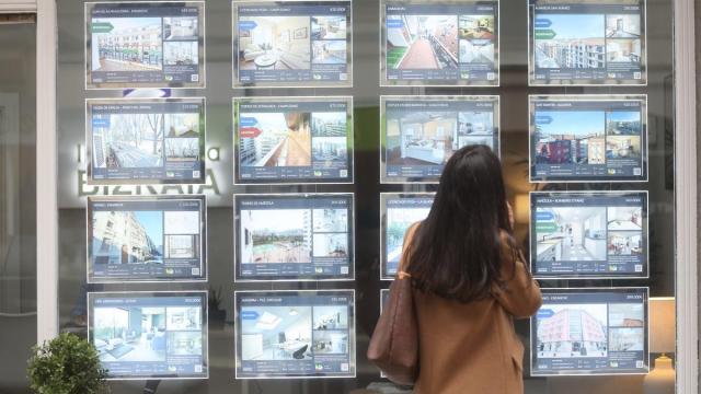 Una joven observa las ofertas de pisos de una inmobiliaria de Bilbao