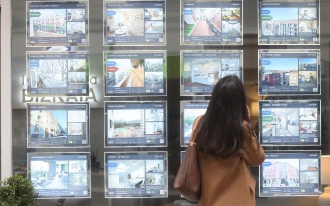Una joven observa las ofertas de pisos de una inmobiliaria de Bilbao