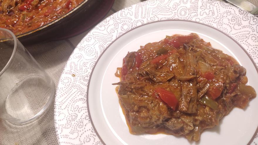 Una ración de ropa vieja, que se puede completar con dados de patata fritos.