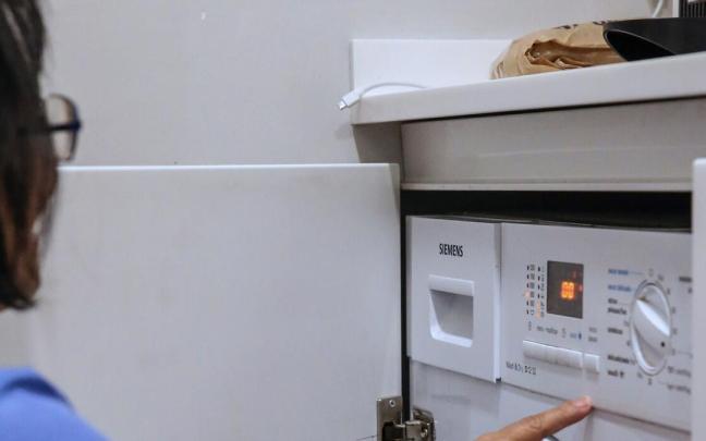 Una persona pone una lavadora.