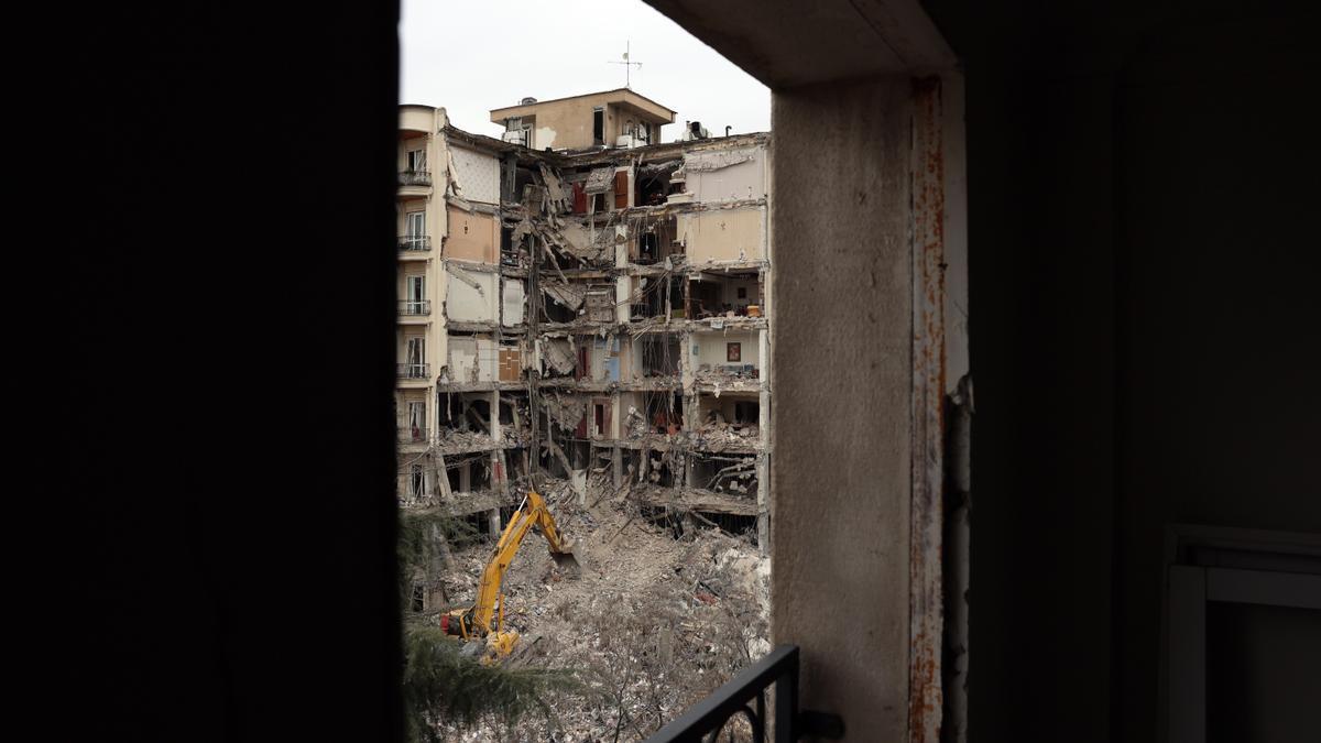 Bomberos y funcionarios iraníes trabajan en el lugar donde se encuentran los edificios residenciales dañados en el norte de Teherán
