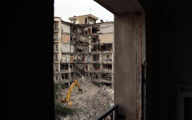 Bomberos y funcionarios iraníes trabajan en el lugar donde se encuentran los edificios residenciales dañados en el norte de Teherán