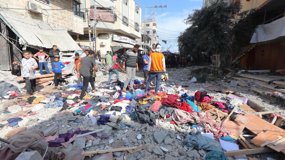 Un grupo de palestinos revisa los escombros de un edificio para tratar de localizar los cuerpos de familiares y allegados.
