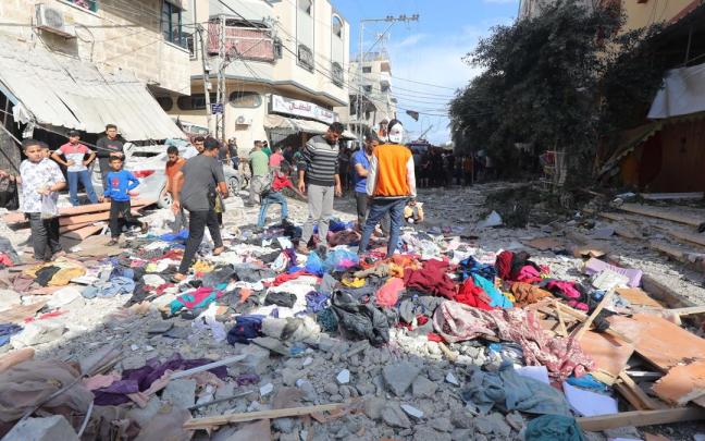 Un grupo de palestinos revisa los escombros de un edificio para tratar de localizar los cuerpos de familiares y allegados.