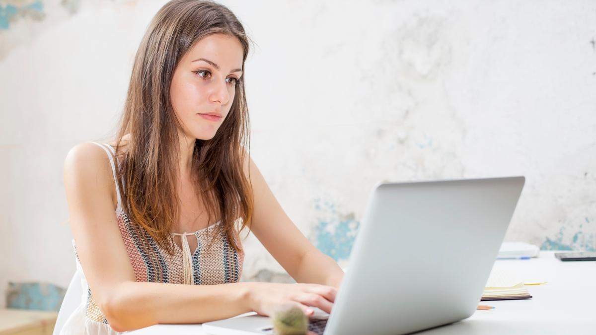 Una joven estudia con un ordenador portátil.