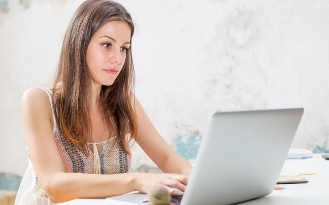 Una joven estudia con un ordenador portátil.