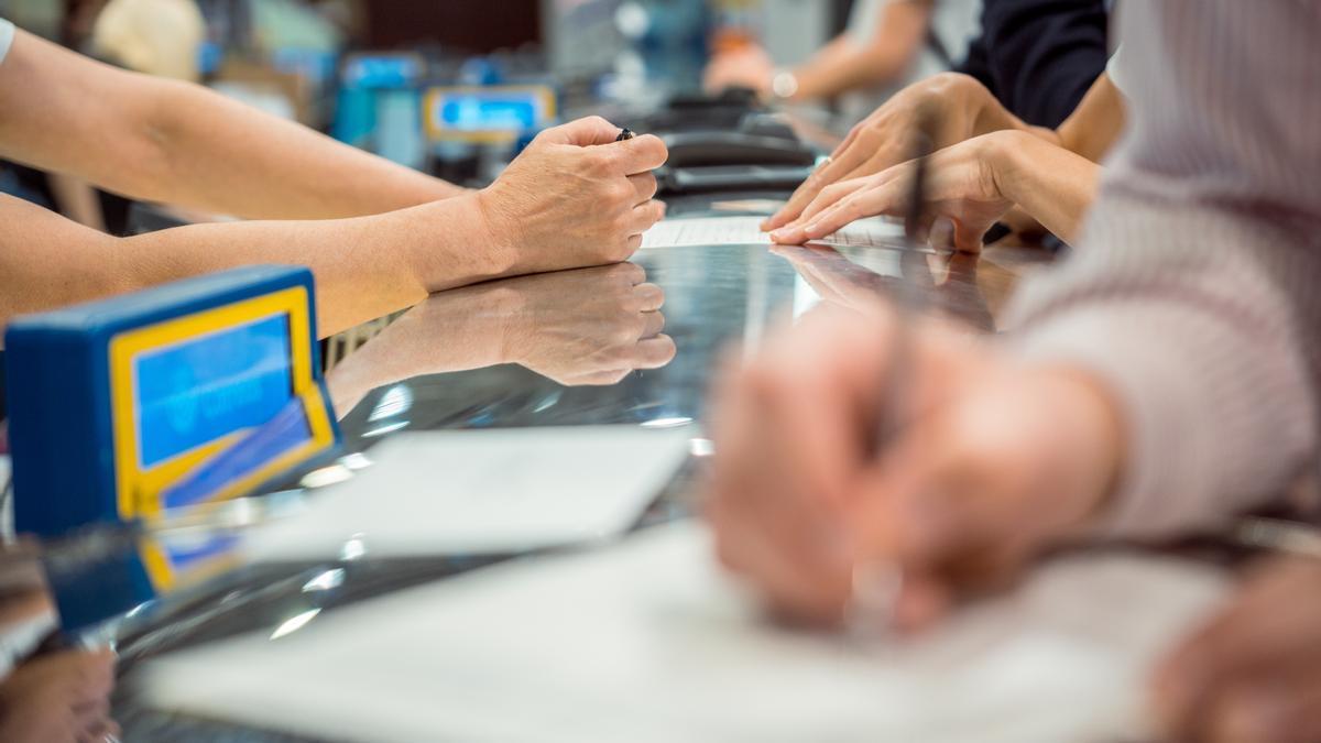 Varias personas rellenan documentos