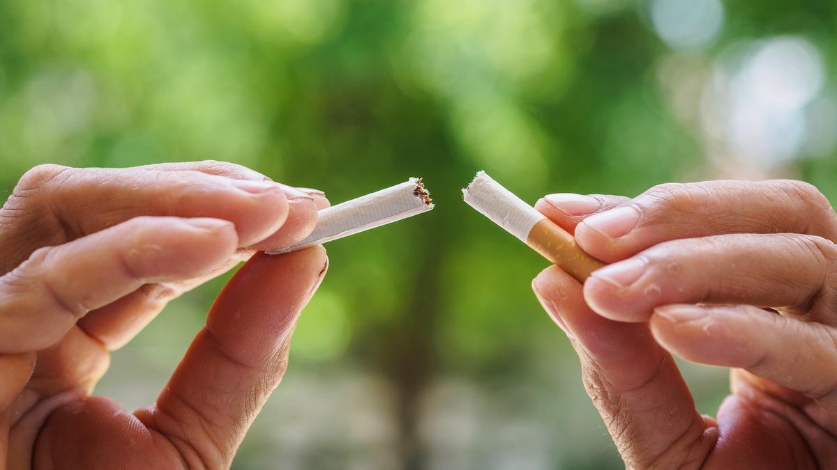 Un hombre parte un cigarrillo por la mitad.