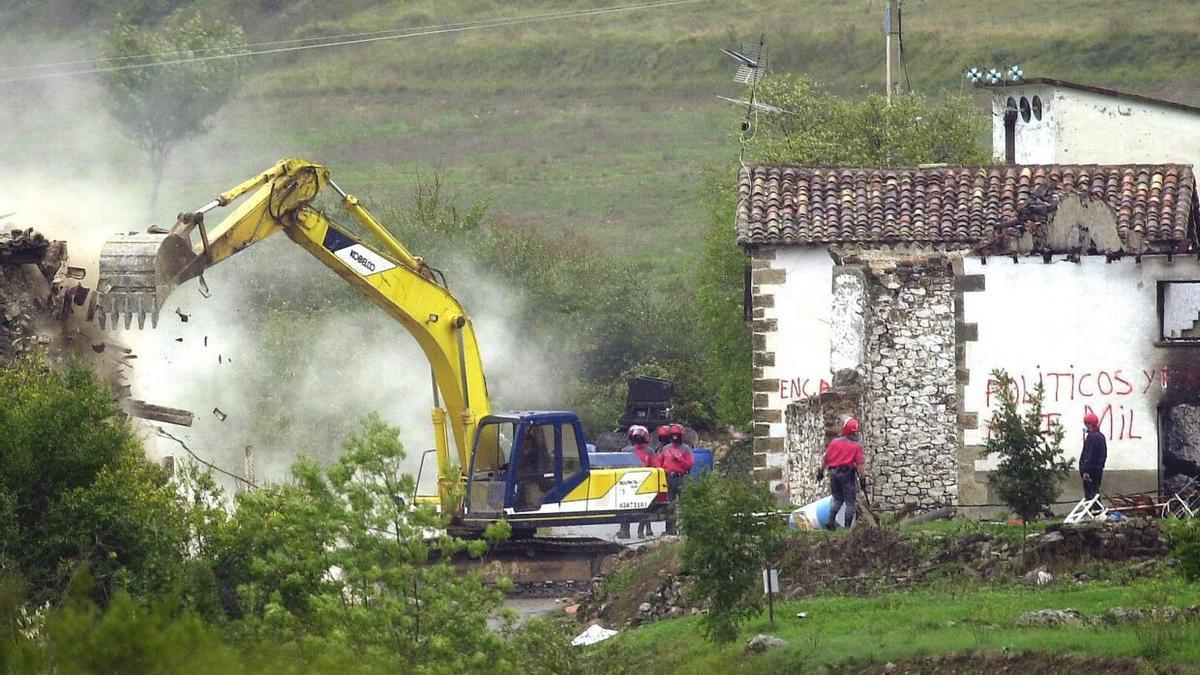 Una pala derriba una de las primeras casas de la localidad, el 30 de septiembre de 2003.