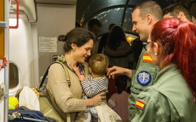 Una mujer y su bebé a la llegada a Madrid de los pasajeros evacuados desde Omán.