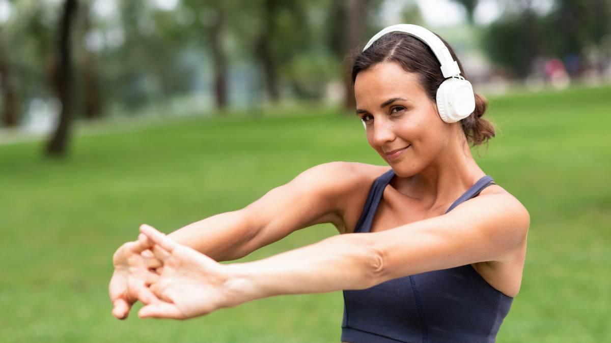 Chica realiza estiramientos con los brazos antes de empezar a correr