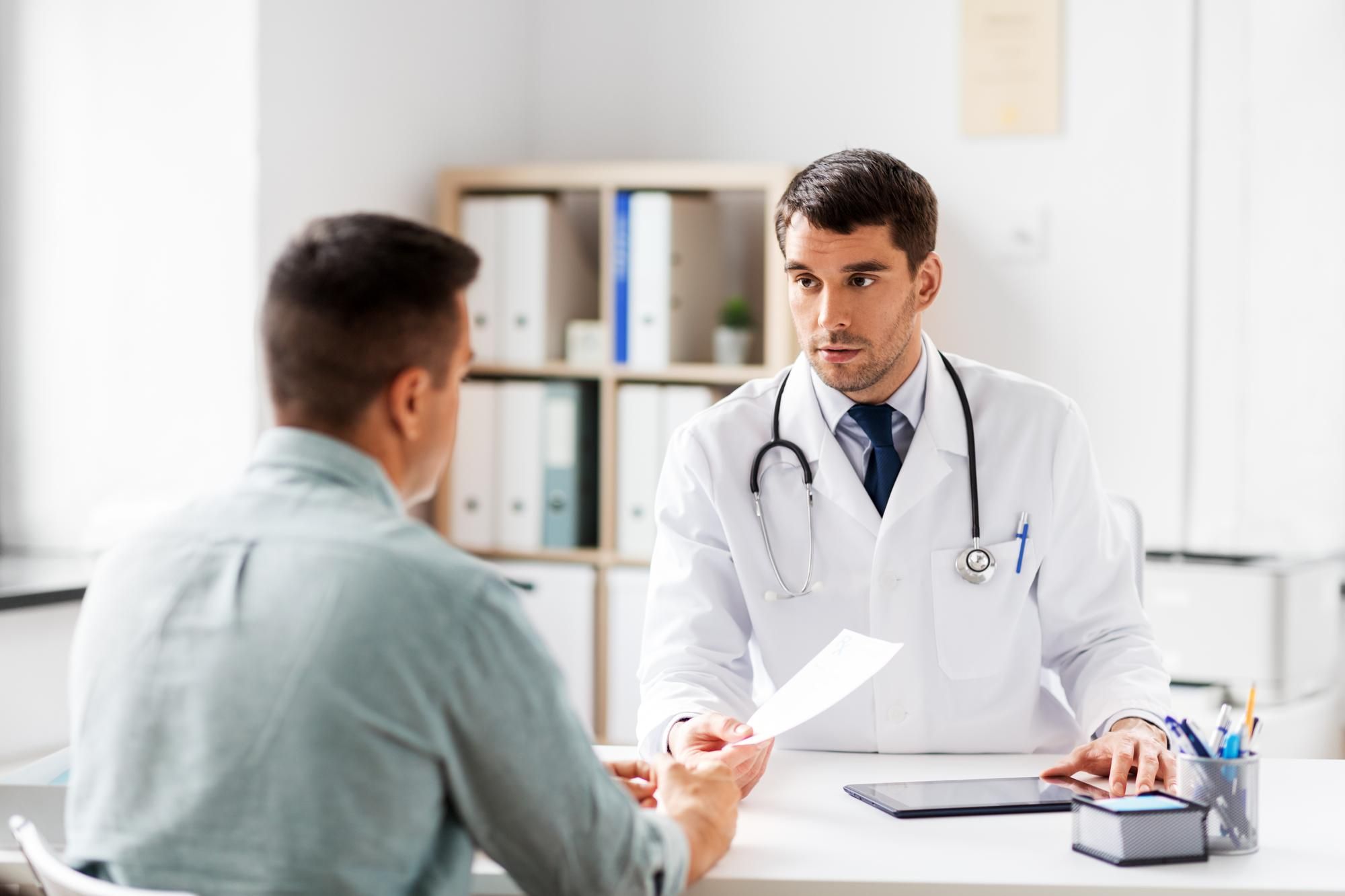 Un médico extiende una receta a un paciente.