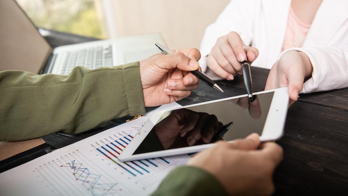 Dos personas consultan gráficos y datos con ayuda de una tablet