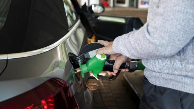 Un hombre echa gasolina en una estación de servicio.