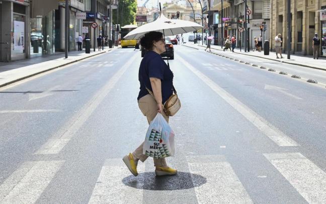 Una mujer se protege del sol con un paraguas.