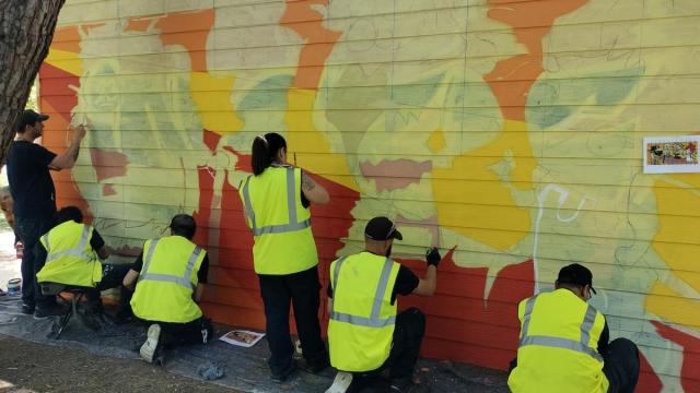 El equipo del taller de empleo sobre murales de Amurrio trabajando en el txoko laranja del parque Juan Urrutia