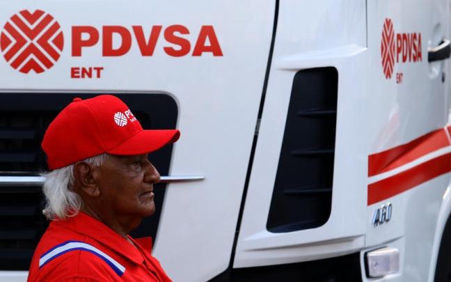 Un conductor, ante uno de los camiones de la petrolera estatal venezolana PDVSA.