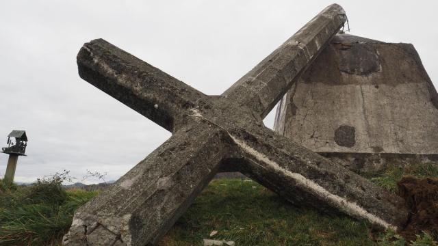 La cruz yace sobre el suelo de la cima de Morkaiko, sujetada en parte por el pedestal.