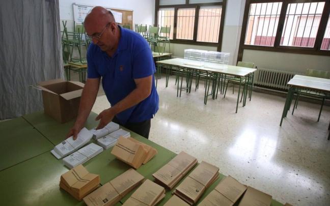 Un operario coloca papeletas en el instituto Padre Moret Irubide de Pamplona